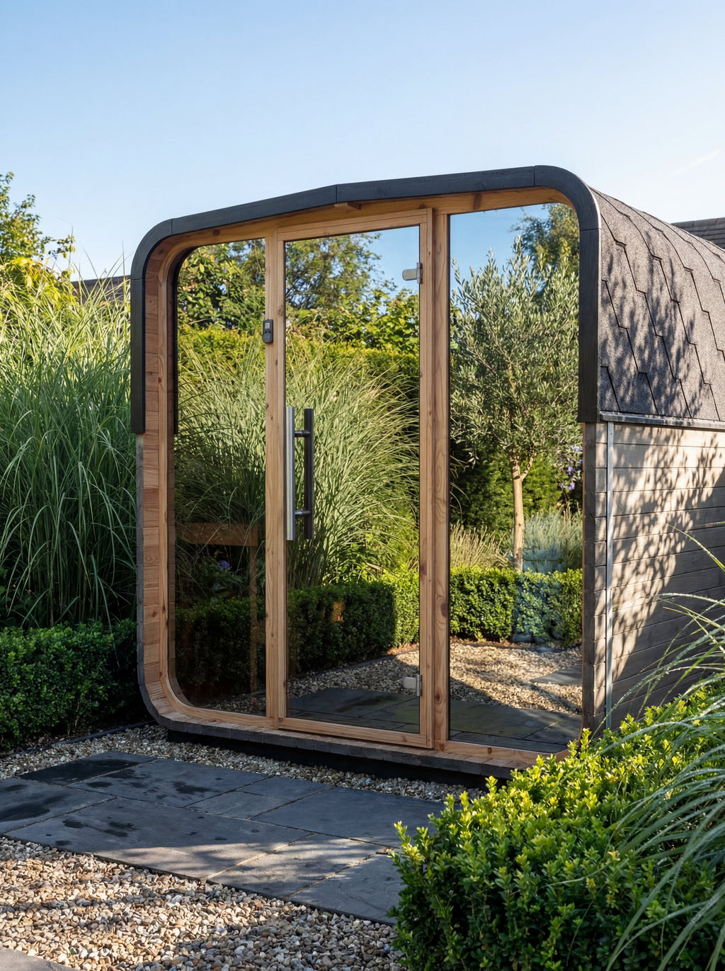 Auroom Sola 210 barrel sauna with mirrored glass front, garden lifestyle setting
